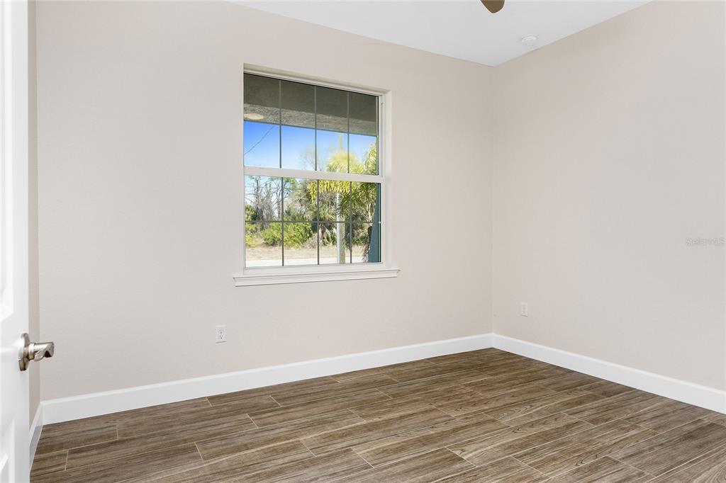 399 Sunset Road Rotonda West, FL 33947 - Photo 27 of 57 a view of an empty room with wooden floor and a window