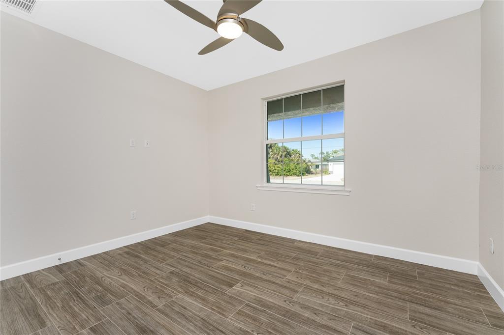 399 Sunset Road Rotonda West, FL 33947 - Photo 29 of 57 wooden floor in an empty room with a window