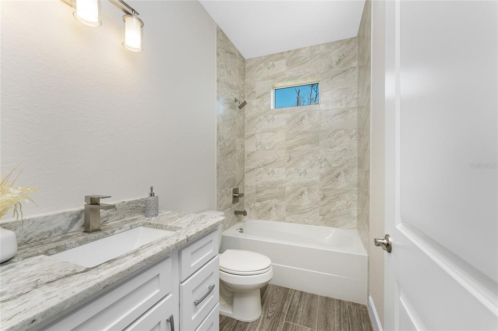 399 Sunset Road Rotonda West, FL 33947 - Photo 30 of 57 a bathroom with a granite countertop sink a toilet and shower