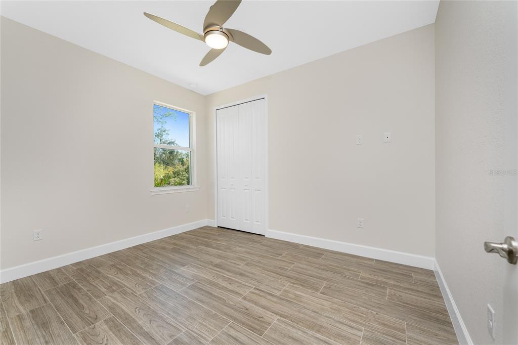 399 Sunset Road Rotonda West, FL 33947 - Photo 33 of 57 an empty room with a window and a ceiling fan