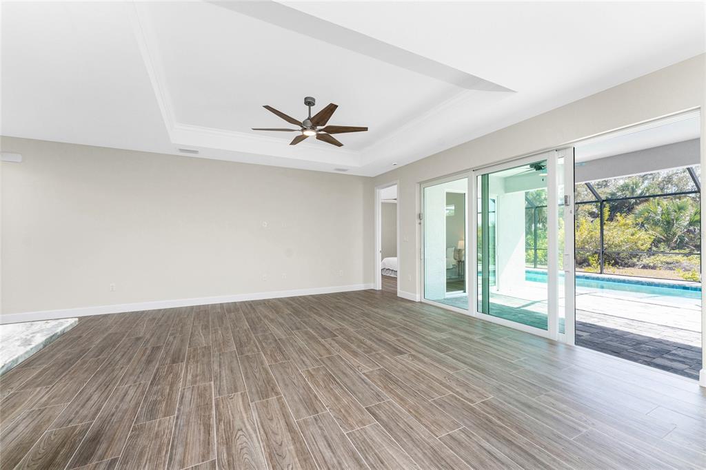 399 Sunset Road Rotonda West, FL 33947 - Photo 4 of 57 an empty room with wooden floor and windows