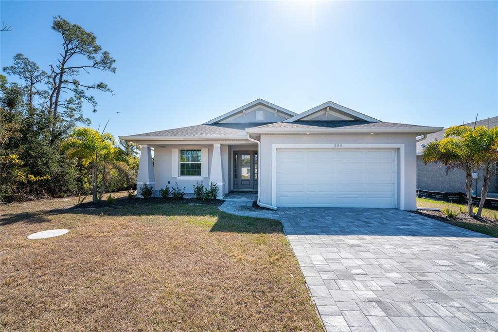 399 Sunset Road Rotonda West, FL 33947 - Photo 48 of 57 a front view of a house with a yard and garage