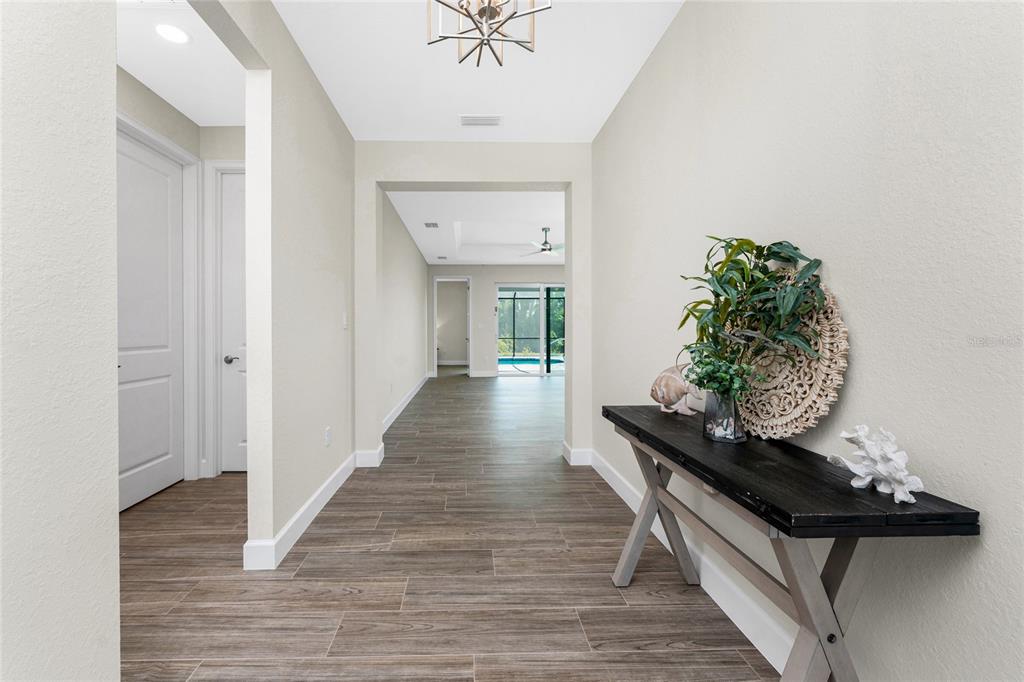 399 Sunset Road Rotonda West, FL 33947 - Photo 8 of 57 a living room with wooden floor and a hallway