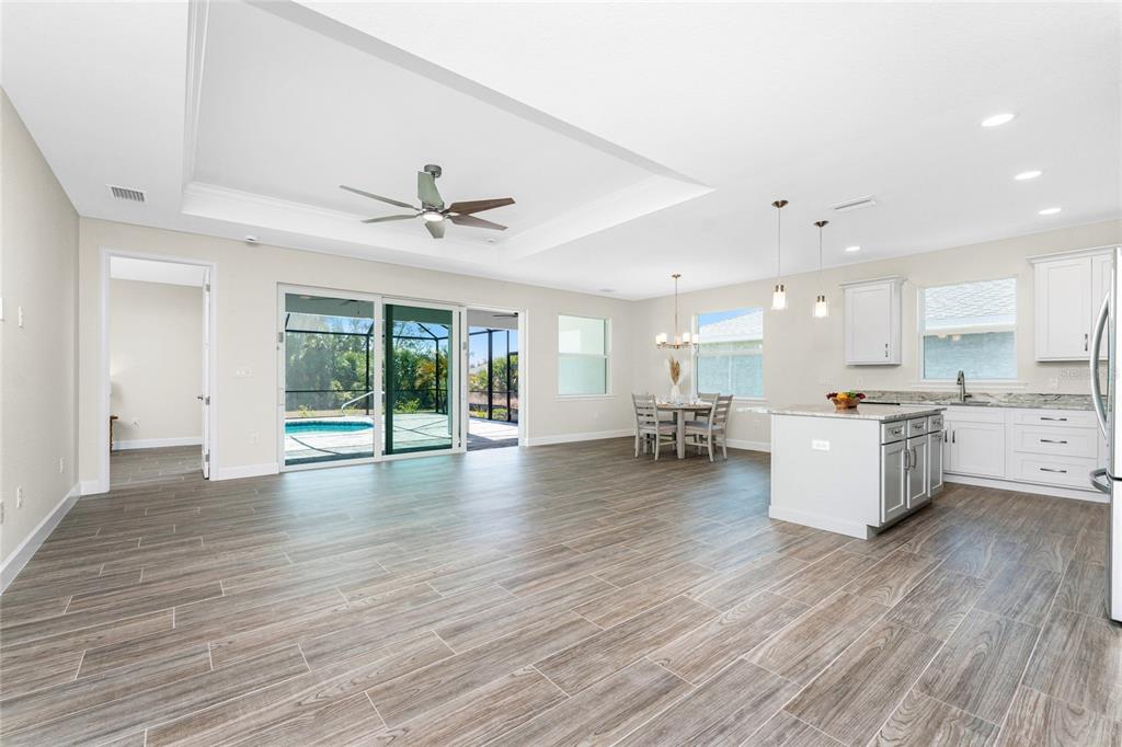 399 Sunset Road Rotonda West, FL 33947 - Photo 10 of 57 a view of an empty room and kitchen with a sink wooden floor