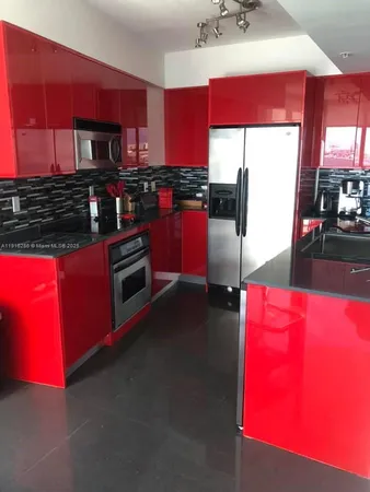 a kitchen with stainless steel appliances kitchen island granite countertop a stove a sink and a refrigerator