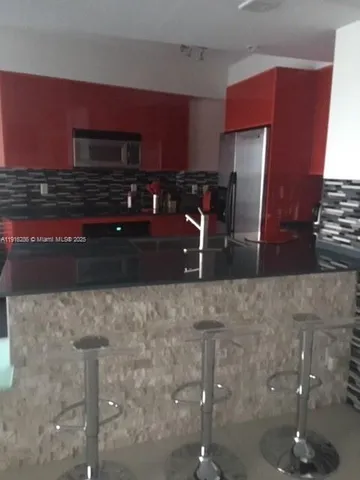 a kitchen with granite countertop a refrigerator and a stove