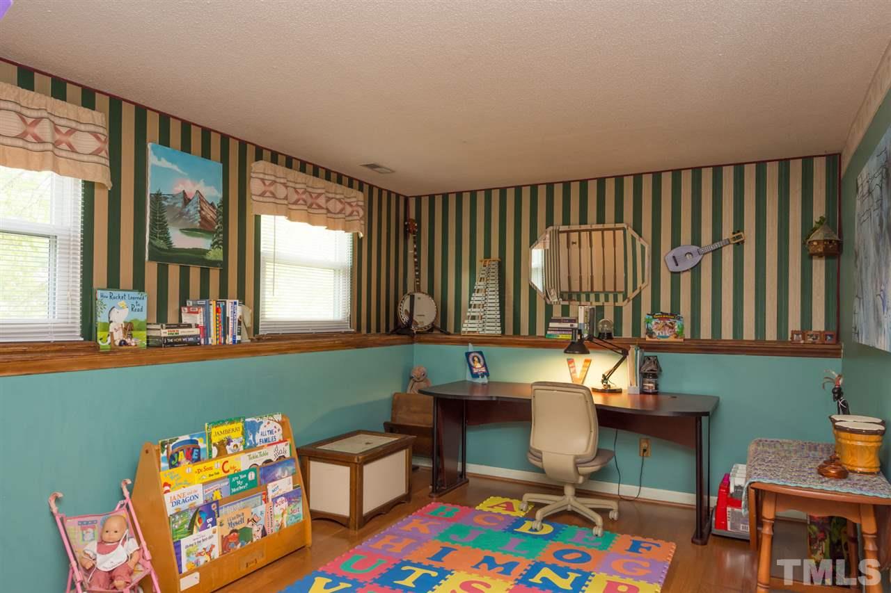 7140 Shellburne Drive Raleigh, NC 27612 - Photo 12 of 22 a reading room with furniture and a baby crib