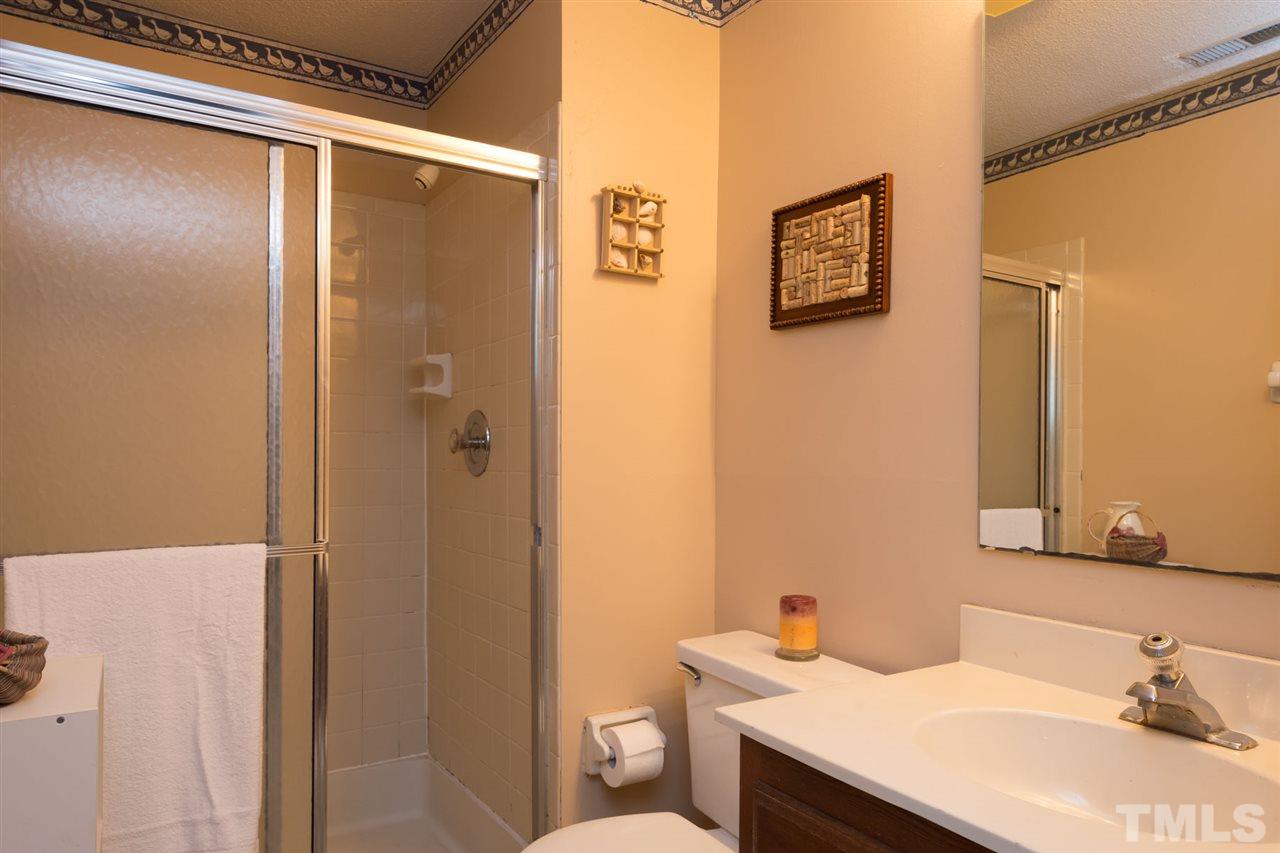 7140 Shellburne Drive Raleigh, NC 27612 - Photo 17 of 22 a bathroom with a sink vanity mirror and toilet