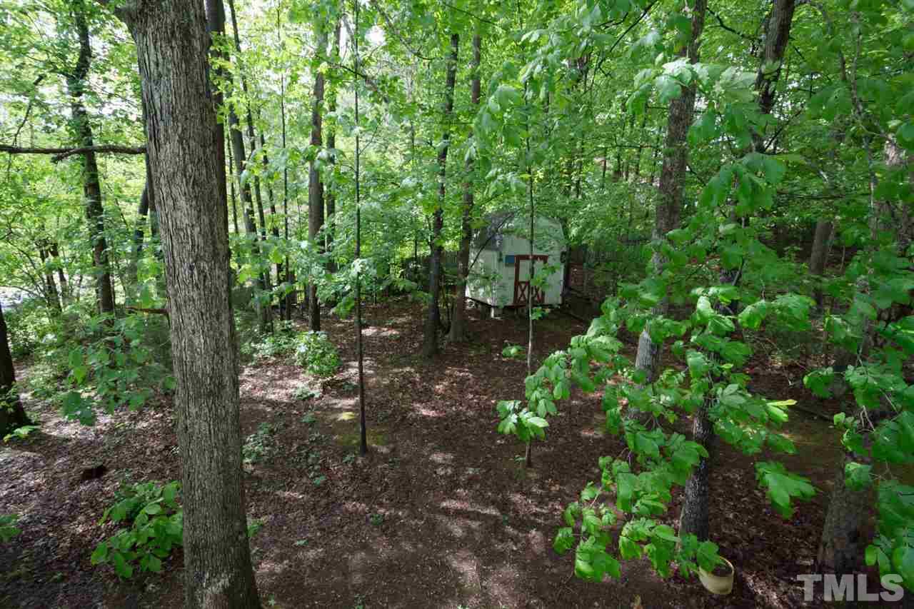 7140 Shellburne Drive Raleigh, NC 27612 - Photo 21 of 22 a backyard of a house with lots of green space and forest view