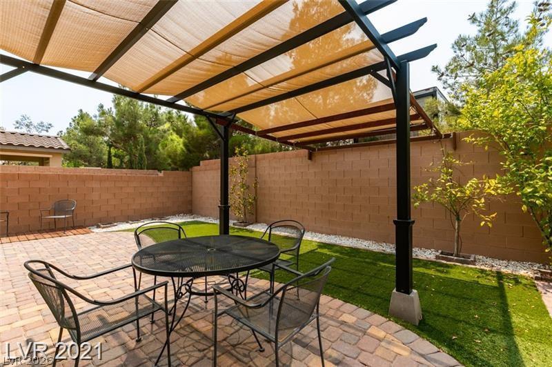 5475 Ordesa Valley Road Las Vegas, NV 89148 - Photo 10 of 35 Enjoy outdoor living with a shaded patio and verdant artificial turf in a private, fenced yard.