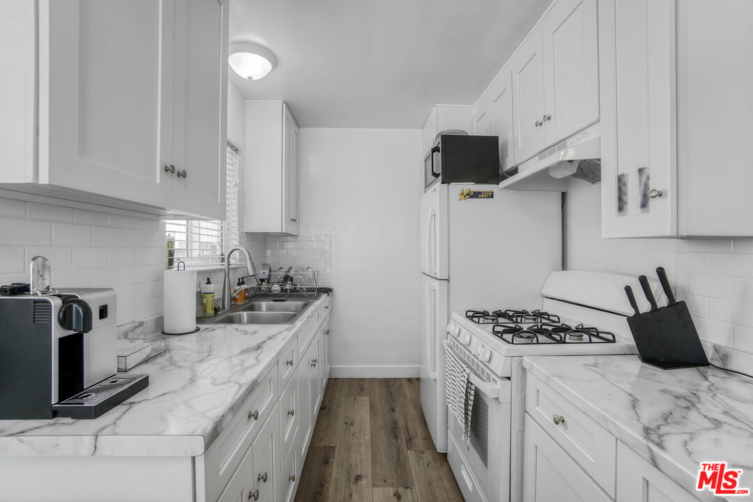 1246 South Saltair Avenue Los Angeles, CA 90025 - Photo 15 of 27 a kitchen with granite countertop a sink stove and refrigerator