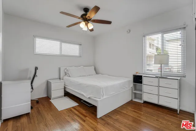 a white bed sitting in a bedroom next to a window