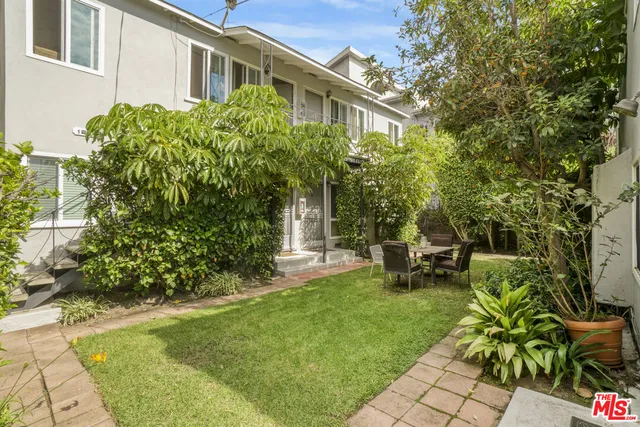 a view of a chair and table in backyard of the house