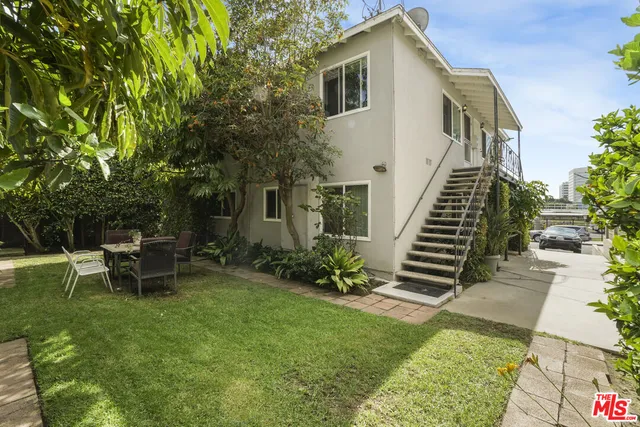a backyard of a house with table and chairs