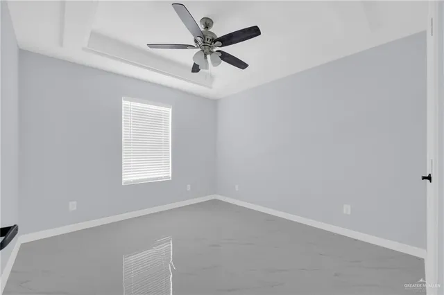 an empty room with a window and a fan