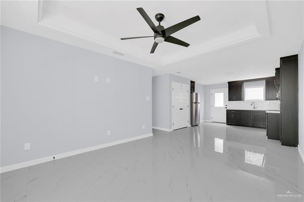 1620 Shadow Creek Drive, Unit 3 Weslaco, TX 78599 - Photo 5 of 14 a view of a livingroom with a ceiling fan & kitchen space