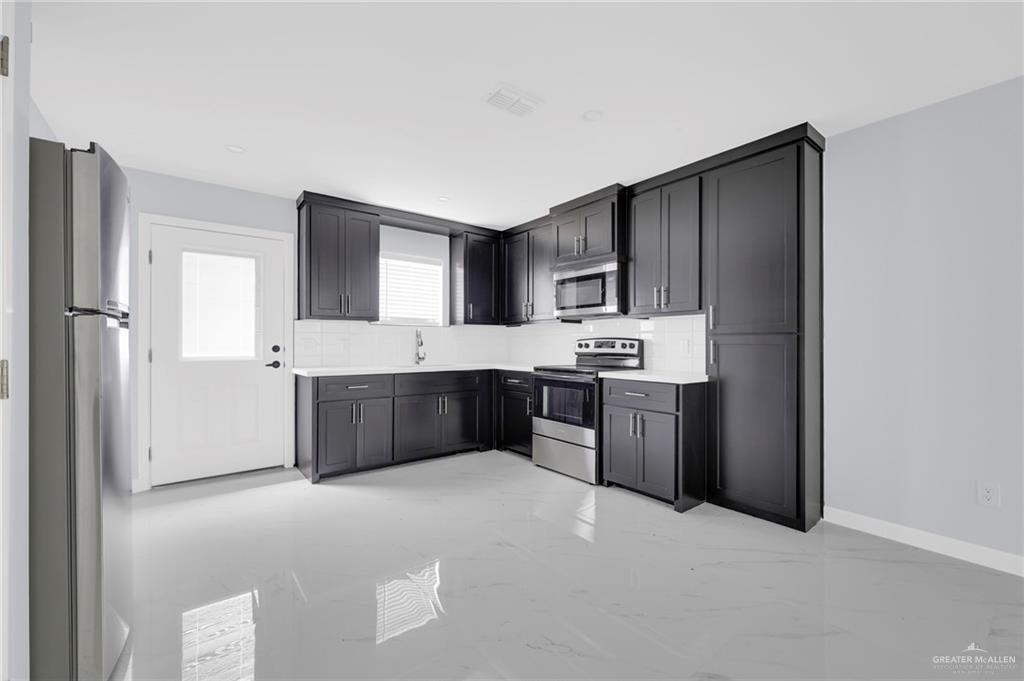 1620 Shadow Creek Drive, Unit 3 Weslaco, TX 78599 - Photo 6 of 14 a kitchen with stainless steel appliances a refrigerator and a sink
