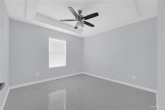 an empty room with a window and ceiling fan