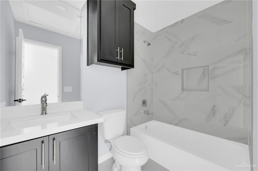 1620 Shadow Creek Drive, Unit 3 Weslaco, TX 78599 - Photo 9 of 14 a bathroom with a sink a toilet and shower