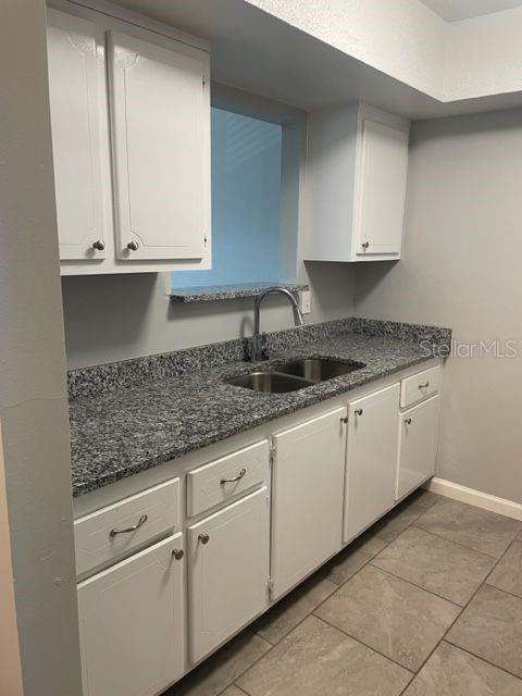 675 Indian Rocks Road North, Unit 203A Belleair Bluffs, FL 33770 - Photo 3 of 9 a kitchen with granite countertop white cabinets and a sink