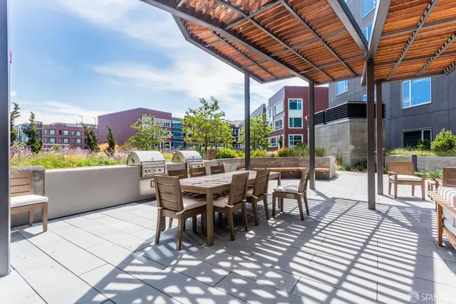 a view of a patio with a dining table and chairs with wooden floor