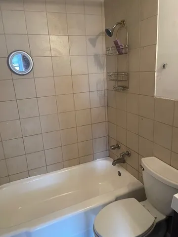 a bathroom with a toilet and a bath tub