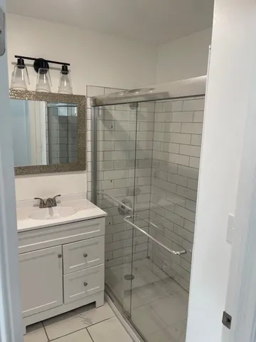 a bathroom with a shower sink and mirror