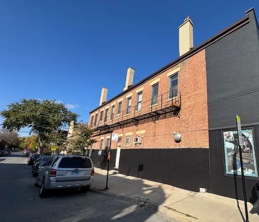 a front view of a building with cars parked