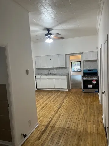 a view of a kitchen with a sink cabinets and wooden floor