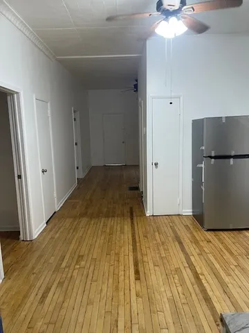 a view of a bedroom with wooden floor and natural light