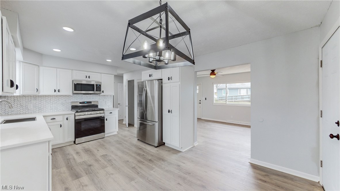 1466 Scenic Way Akron, OH 44310 - Photo 7 of 35 Kitchen with sink, light hardwood / wood-style floors, appliances with stainless steel finishes, ceiling fan, and white cabinets