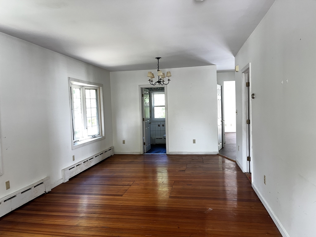 703 Mill Street Marion, MA 02738 - Photo 6 of 16 an empty room with wooden floor and windows
