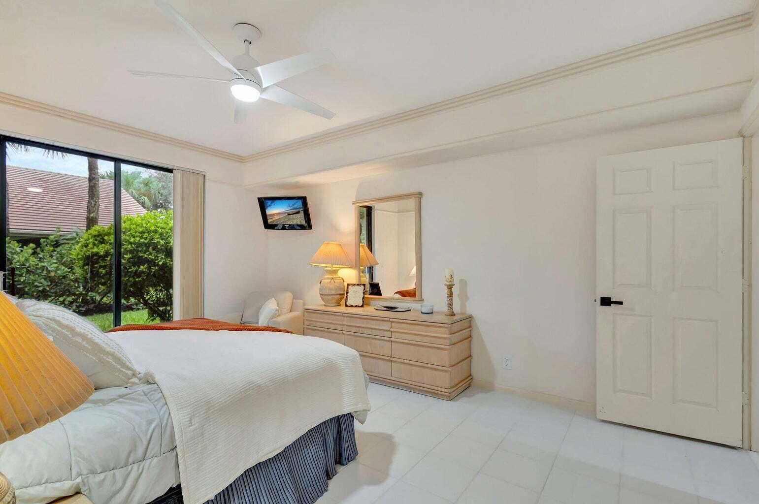16151 West Bay Drive, Unit 161 Jupiter, FL 33477 - Photo 14 of 25 a bedroom with a bed and a large window