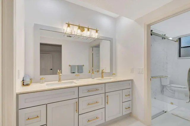 a bathroom with a sink a toilet and a mirror