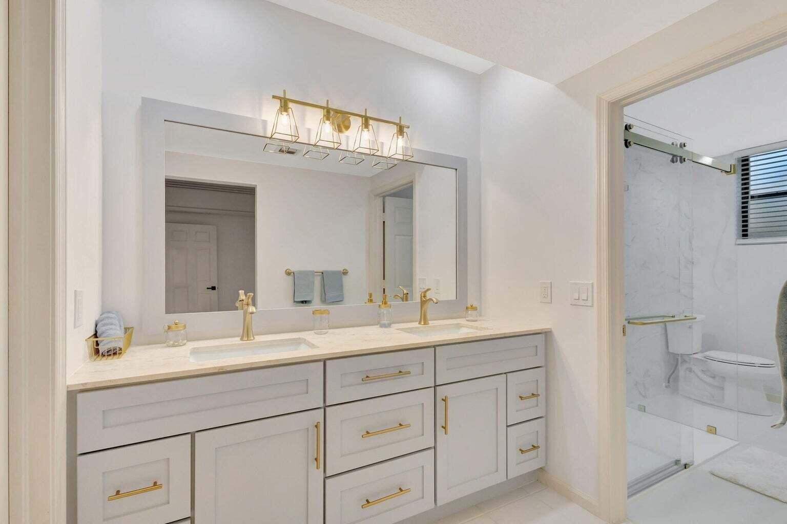 16151 West Bay Drive, Unit 161 Jupiter, FL 33477 - Photo 16 of 25 a bathroom with a sink a toilet and a mirror