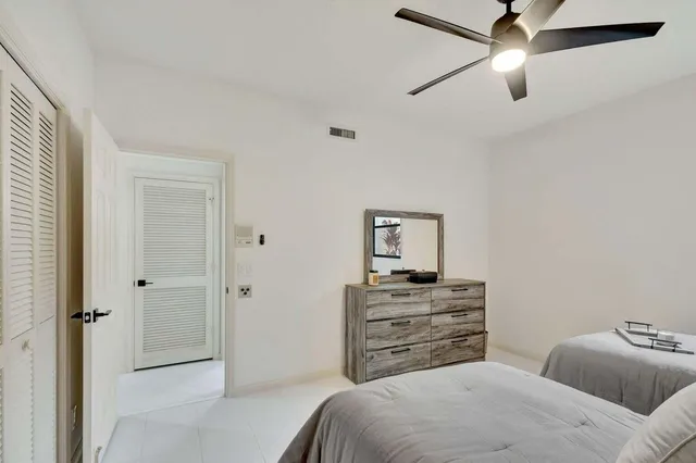 a bedroom with a bed and a ceiling fan