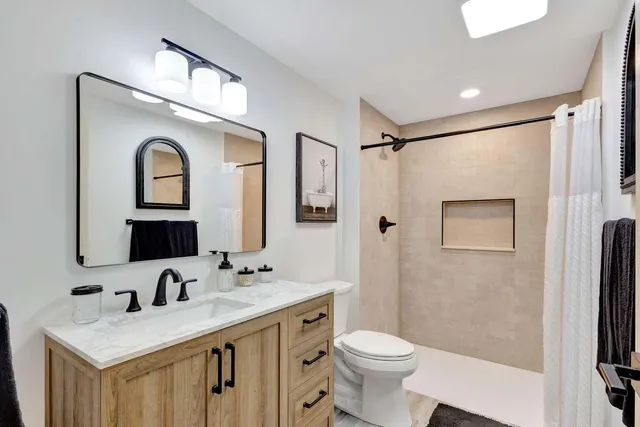 a bathroom with a toilet sink and mirror