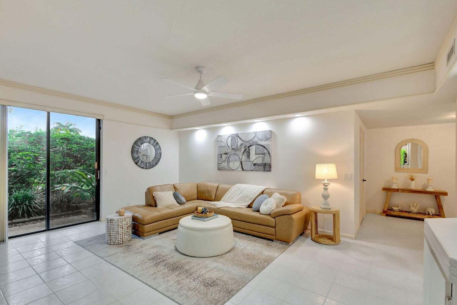 16151 West Bay Drive, Unit 161 Jupiter, FL 33477 - Photo 7 of 25 a living room with furniture a table and a large window