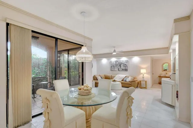 a dining room with furniture a glass table and chandelier