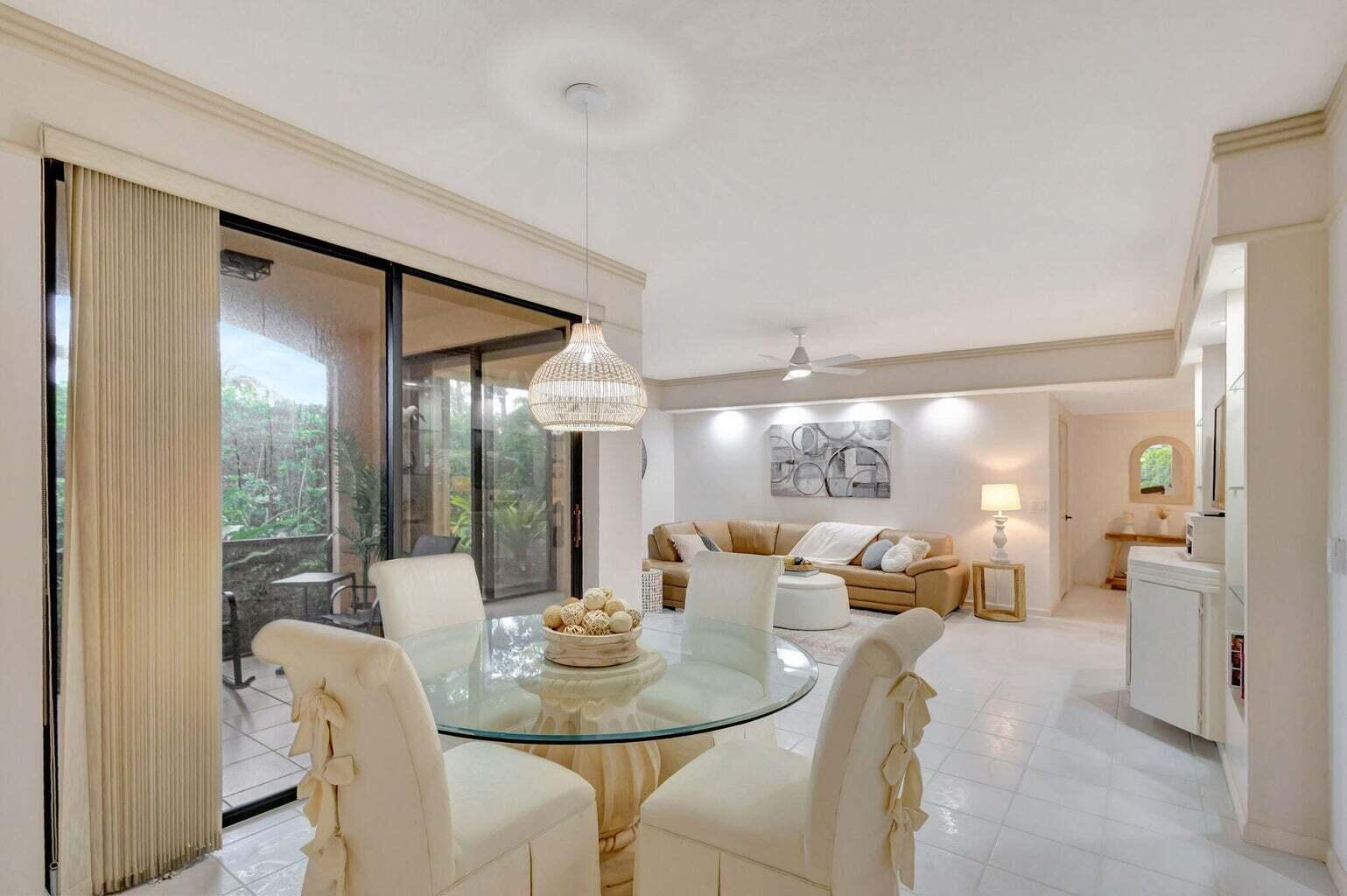 16151 West Bay Drive, Unit 161 Jupiter, FL 33477 - Photo 9 of 25 a dining room with furniture a glass table and chandelier