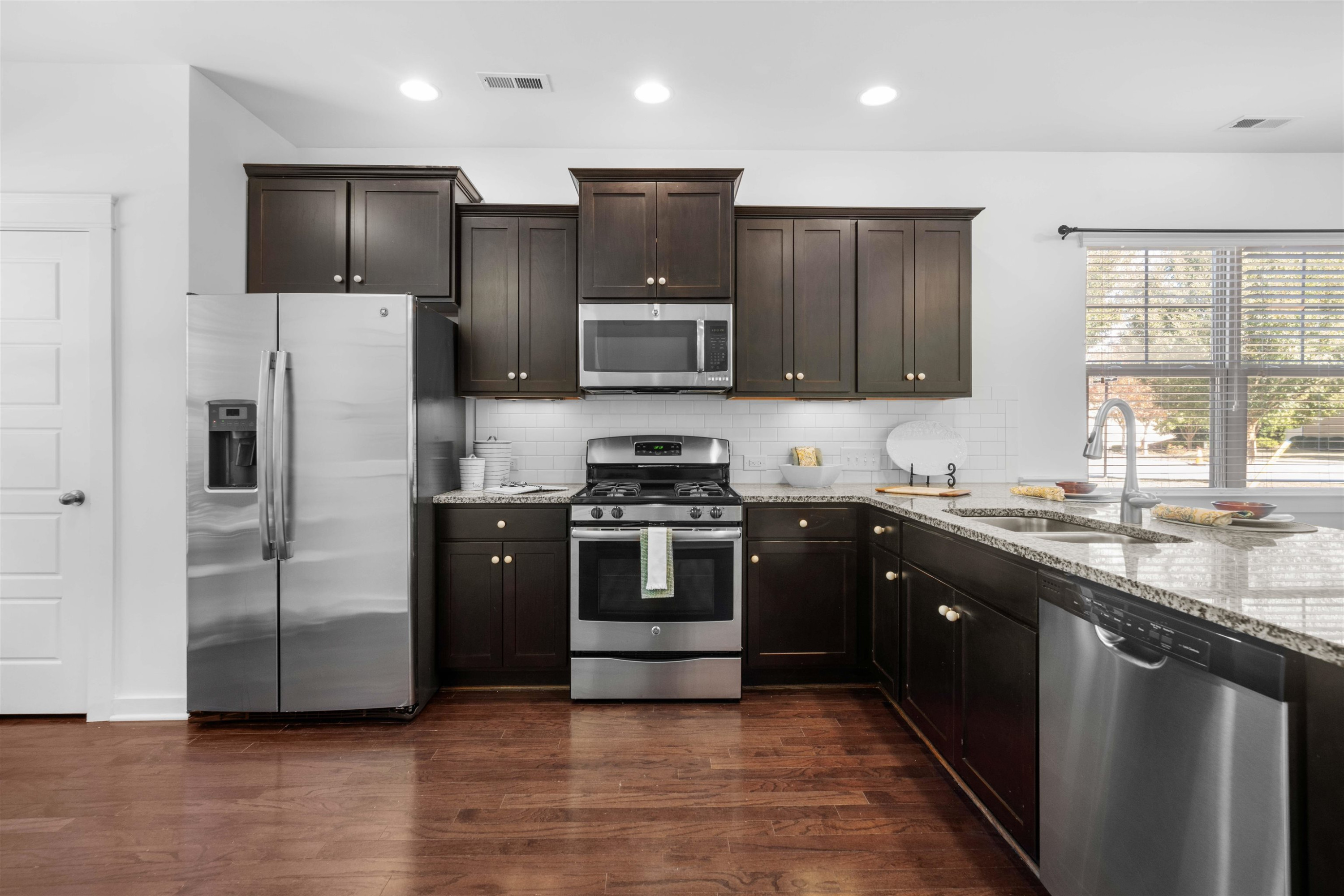 7922 Allscott Way Raleigh, NC 27612 - Photo 12 of 28 a kitchen with stainless steel appliances granite countertop a refrigerator and a stove top oven