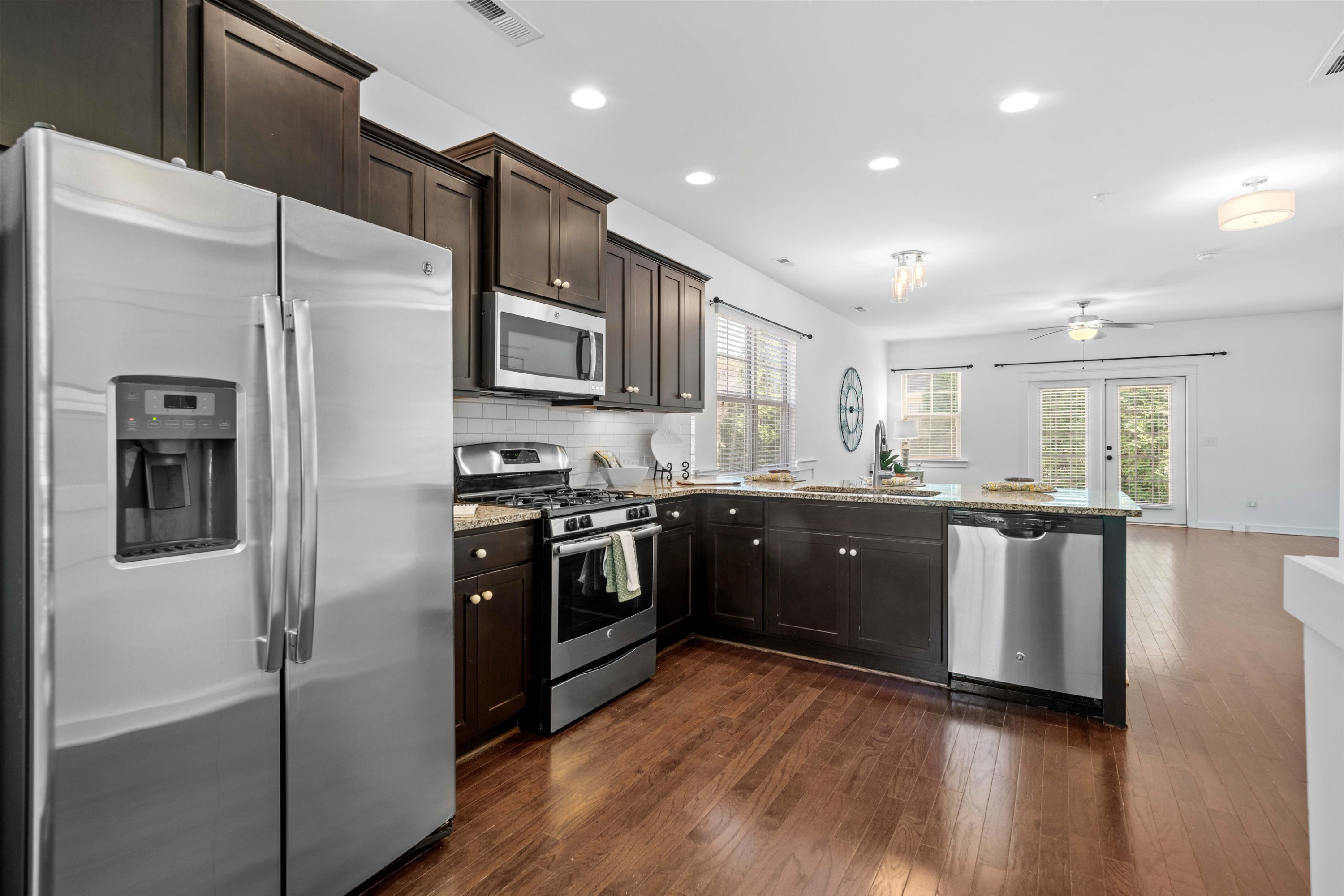 7922 Allscott Way Raleigh, NC 27612 - Photo 13 of 28 a kitchen with stainless steel appliances granite countertop a refrigerator a sink dishwasher a stove and white cabinets with wooden floor