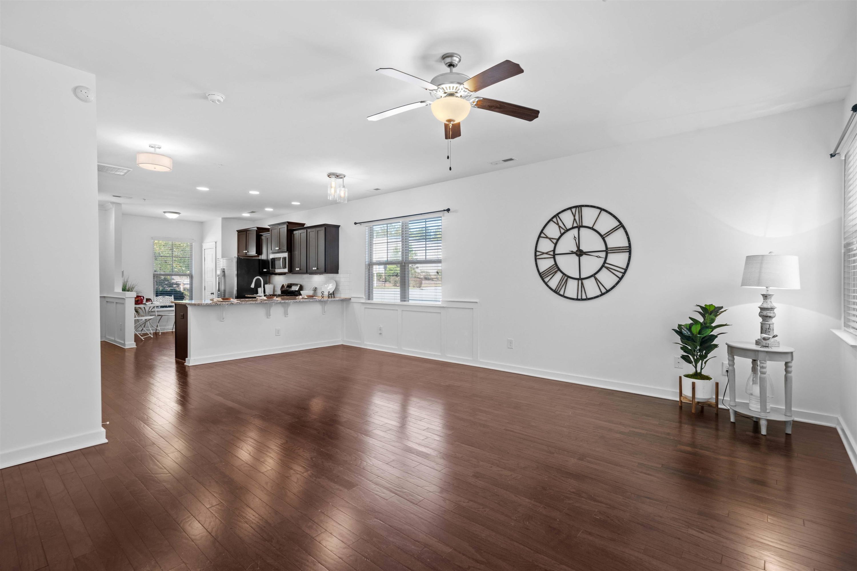 7922 Allscott Way Raleigh, NC 27612 - Photo 7 of 28 a view of an empty room with wooden floor and a ceiling fan