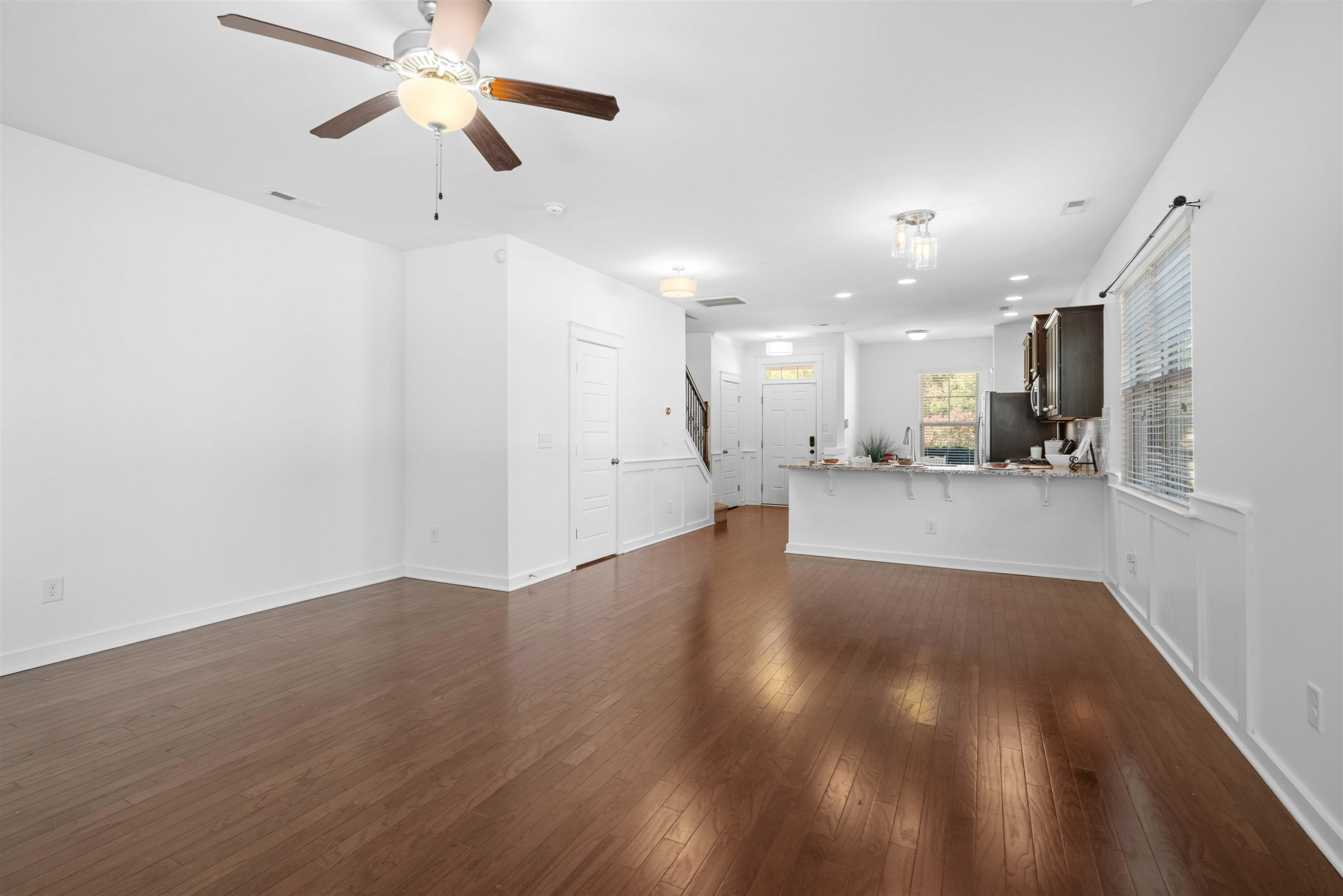 7922 Allscott Way Raleigh, NC 27612 - Photo 10 of 28 a view of an empty room with kitchen appliances and a ceiling fan