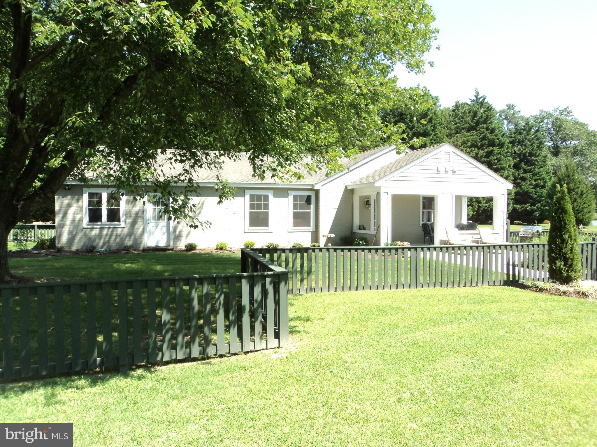 6871 Edge Creek Road St. Michaels, MD 21663 - Photo 5 of 26 a front view of a house with a yard table and chairs