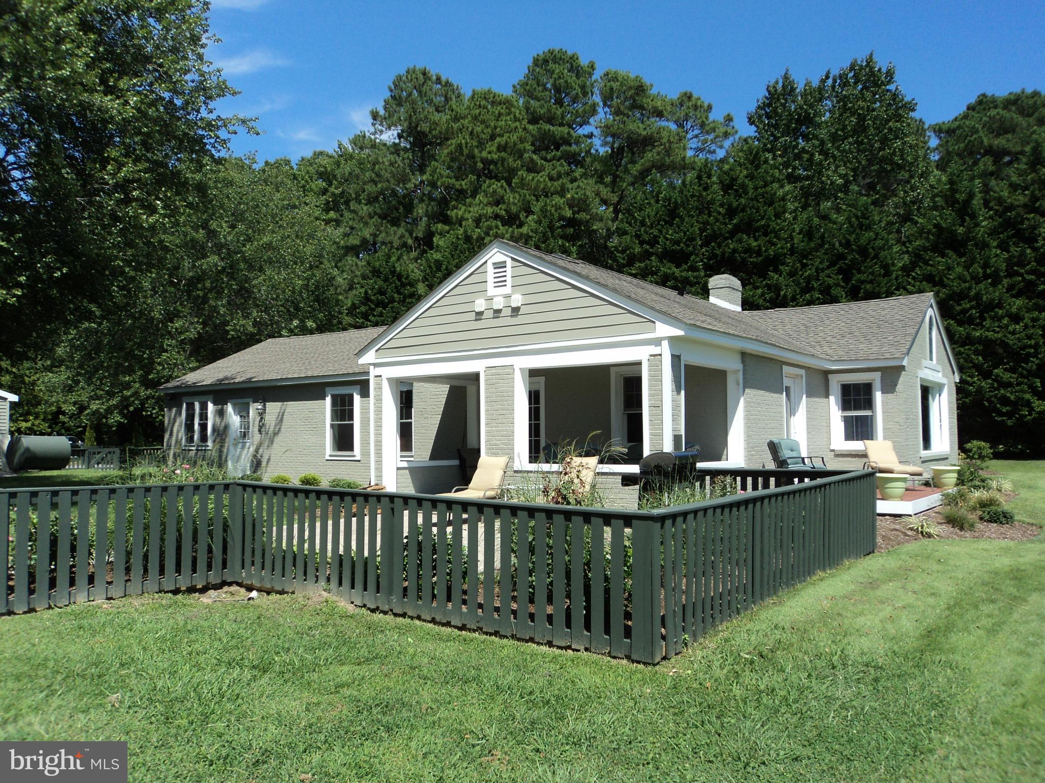6871 Edge Creek Road St. Michaels, MD 21663 - Photo 9 of 26 a front view of a house with a yard table and chairs