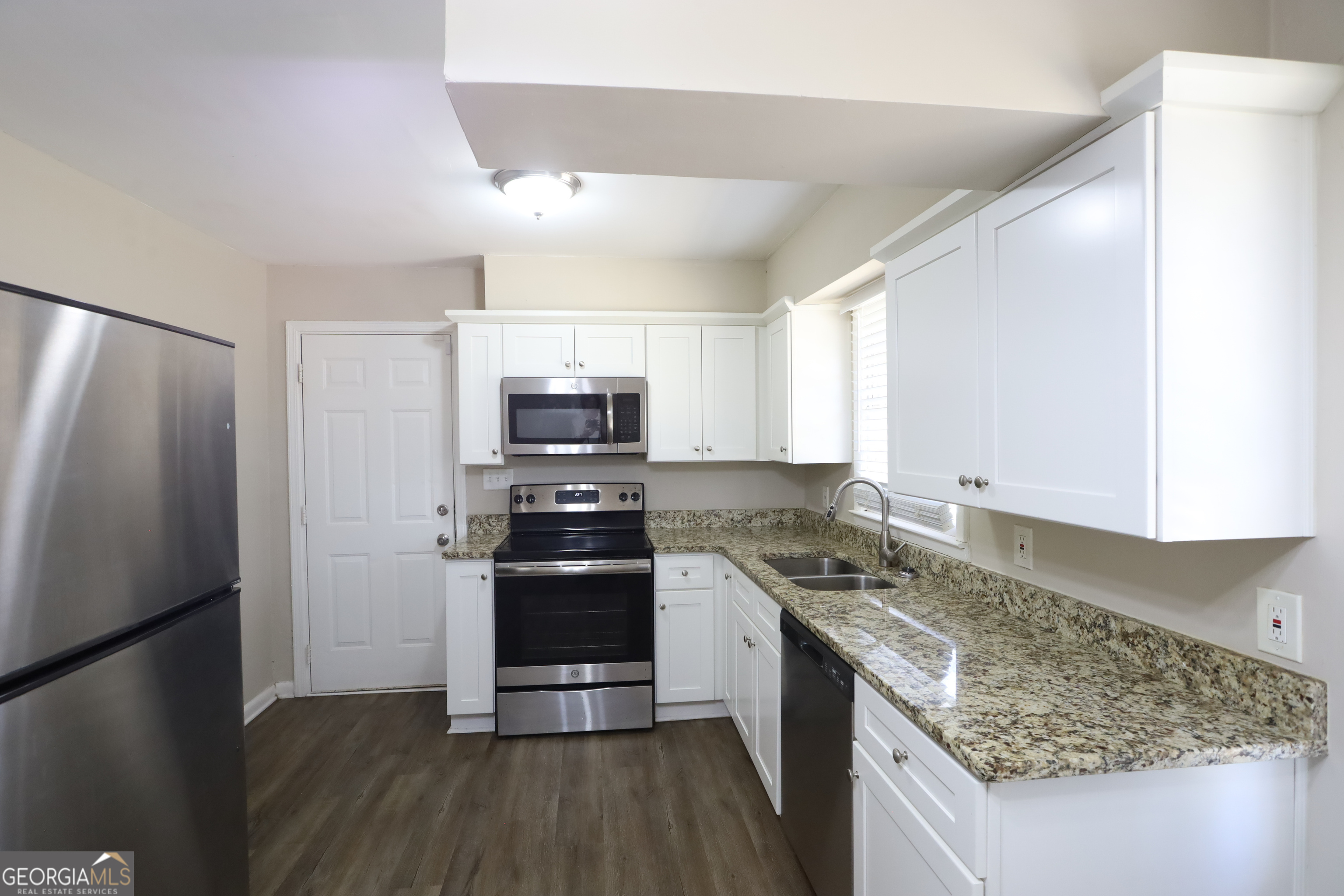 1751 Woodsloe Drive Decatur, GA 30035 - Photo 4 of 9 a kitchen with stainless steel appliances granite countertop a refrigerator and a stove top oven