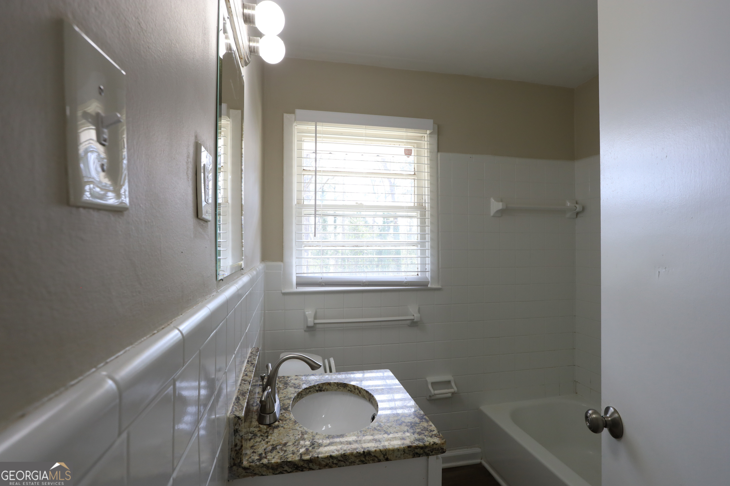 1751 Woodsloe Drive Decatur, GA 30035 - Photo 7 of 9 a bathroom with a sink a window and a mirror
