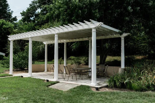 a view of a chair and table in backyard of the house