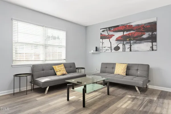a living room with furniture a rug and a window